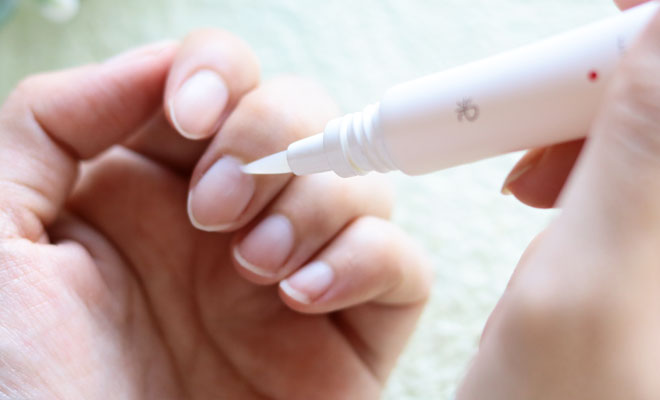 ネイルオイルを指の付け根に塗る