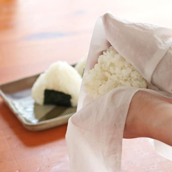 濡らしたはぐくむさらしでアツアツのご飯を握る
